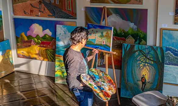 Artist painting in his studio/gallery