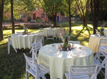 Adobe & Pines garden setting with set tables on the lawn