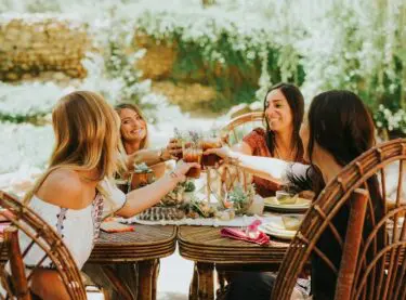a group of women toasting at a table