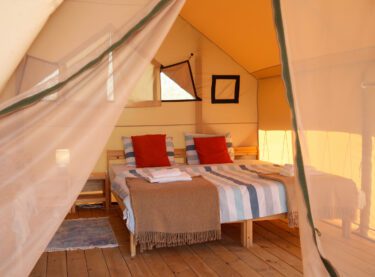 A bed in a luxurious glamping tent