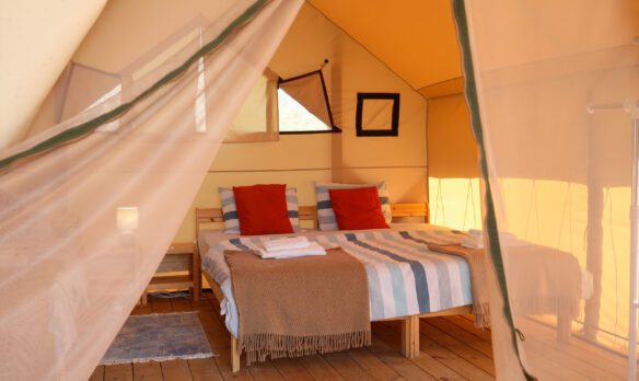 A bed in a luxurious glamping tent
