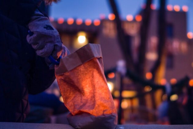Lighting a farolito on Taos Plaza