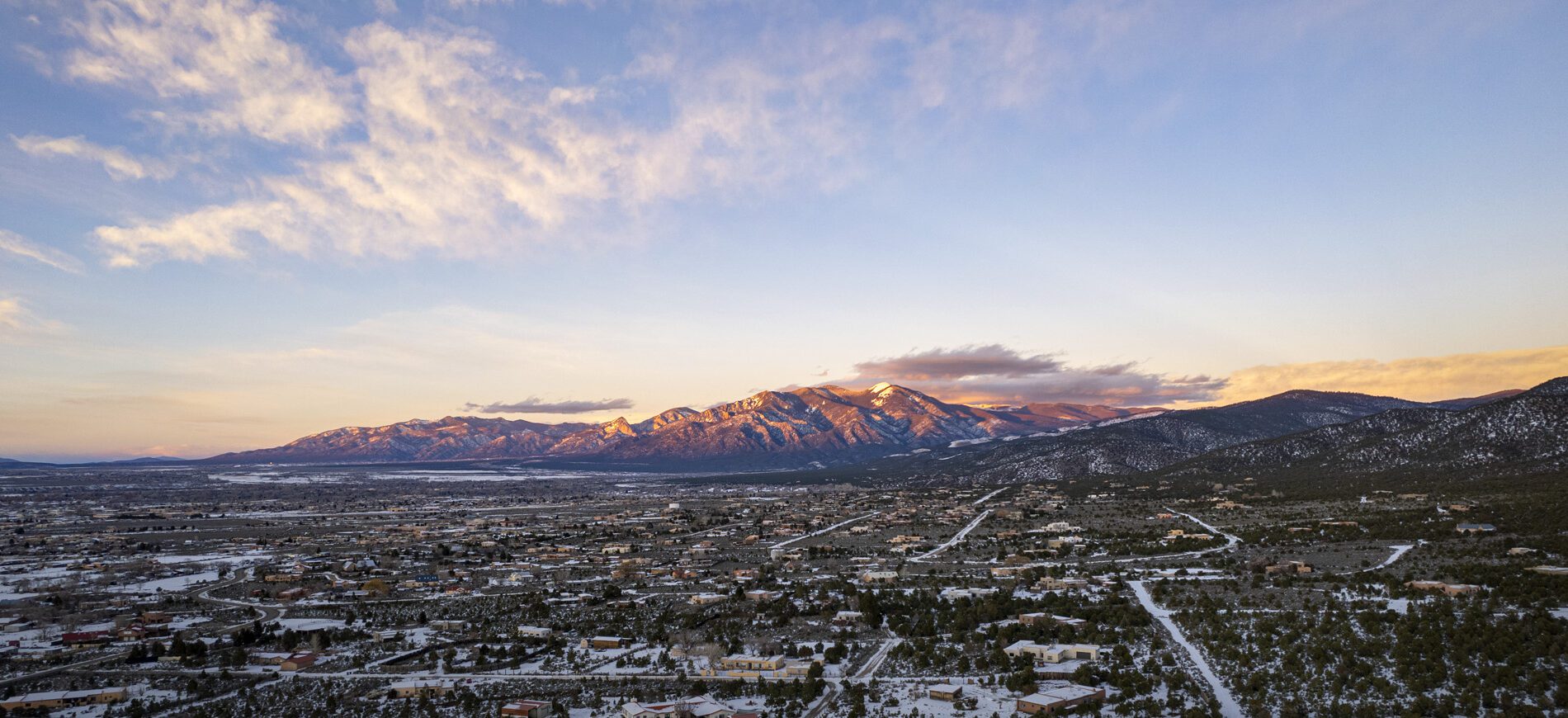 A view of the Taos valley and mountain in winter.