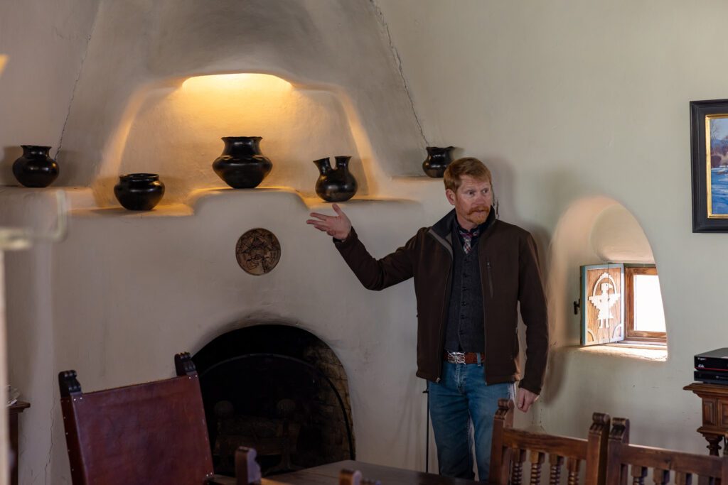 A man in front of the white fireplace