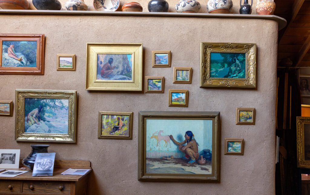 E.I. Couse paintings of native Americans on a brown wall 